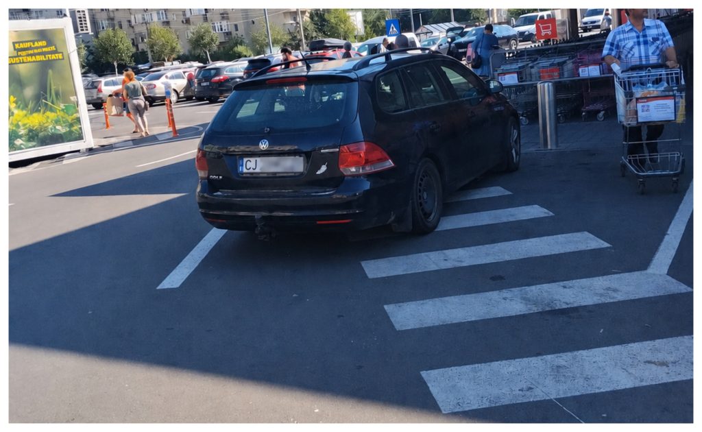 Parcare de big boss in Cluj Napoca Sofer surprins cu masina pe trecerea de pietoni in fata unui supermarket Se distreaza cu o tigara si o cafea